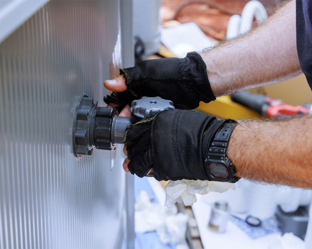 Hands wearing gloves adjusting a pool filter valve, emphasizing pool equipment diagnostics and maintenance.